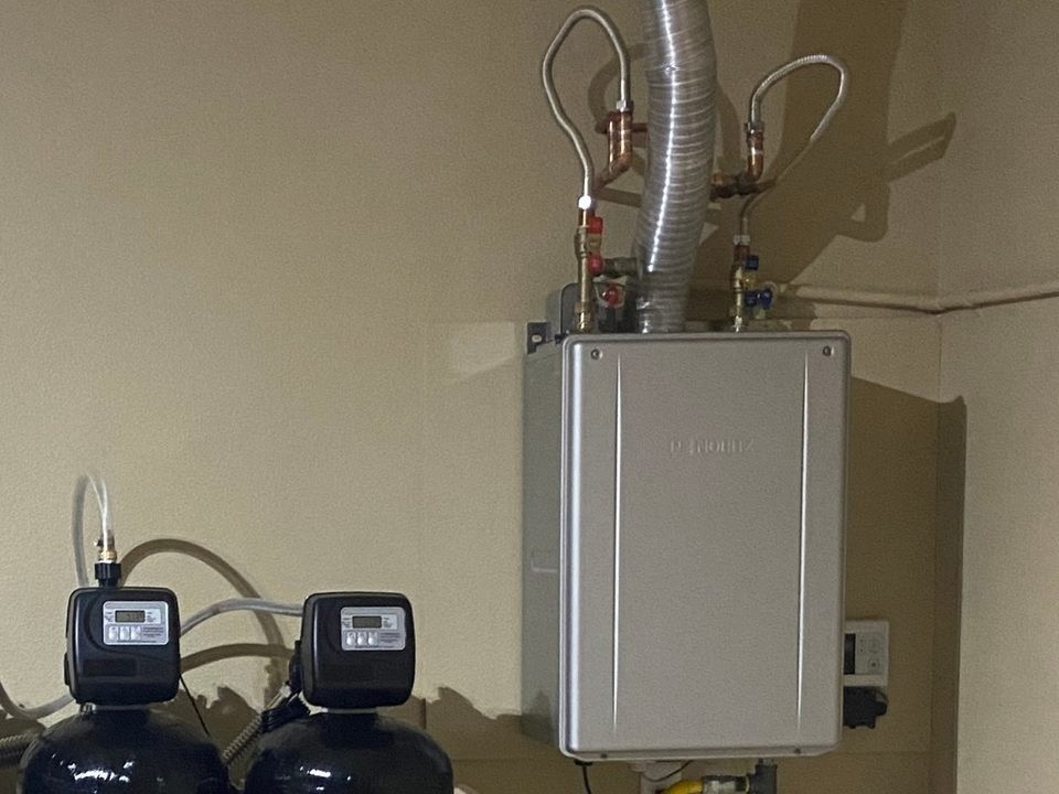 Noritz tankless water heater installed with copper and stainless flex connections and a yellow gas line